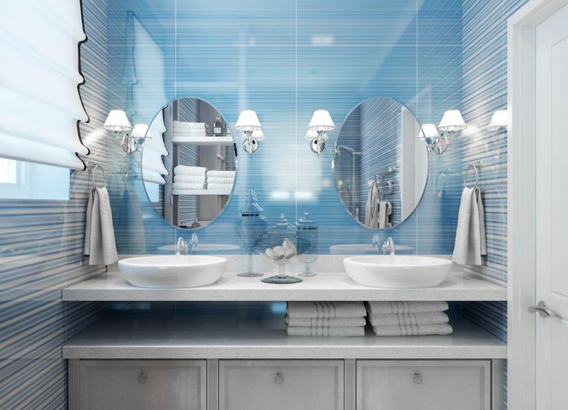 Modern blue bathroom with freestanding tub and
				round mirror